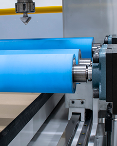 Roller hold-down system used for fast feeding of low-quality or warped panels and processing multiple panels at once on a CNC machine.