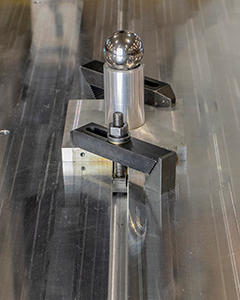 Close-up image of a T-Slot table setup for linear positioning with clamps and vices.