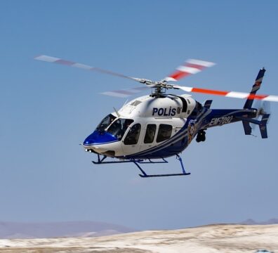 A police helicopter in flight, illustrating the use of C.R. Onsrud CNC machines in manufacturing helicopter skids and structural framing for the aviation industry.
