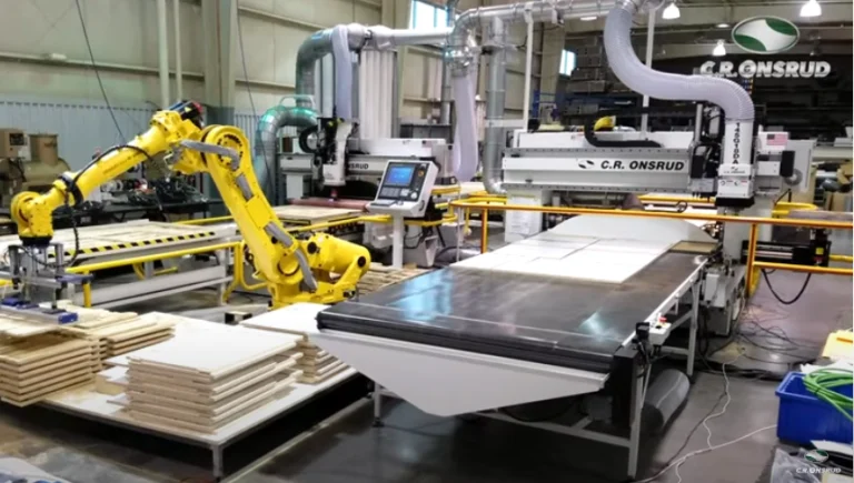 Robotic arm loading MDF panels onto a C.R. Onsrud CNC machine for processing in an automated industrial setup.